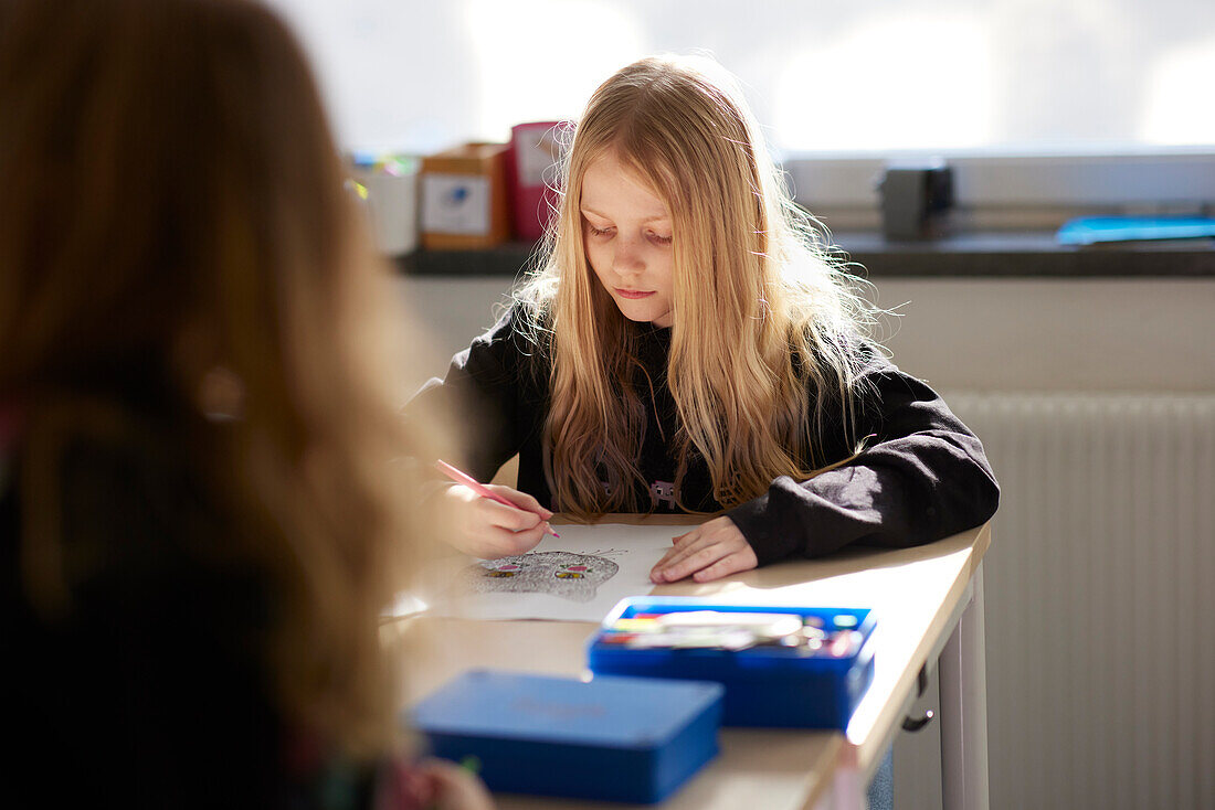 Mädchen sitzt im Klassenzimmer