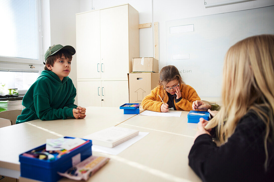 Students sitting at table in classroom