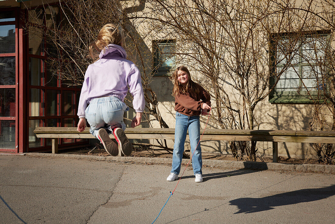 Girls jumping rope outdoors