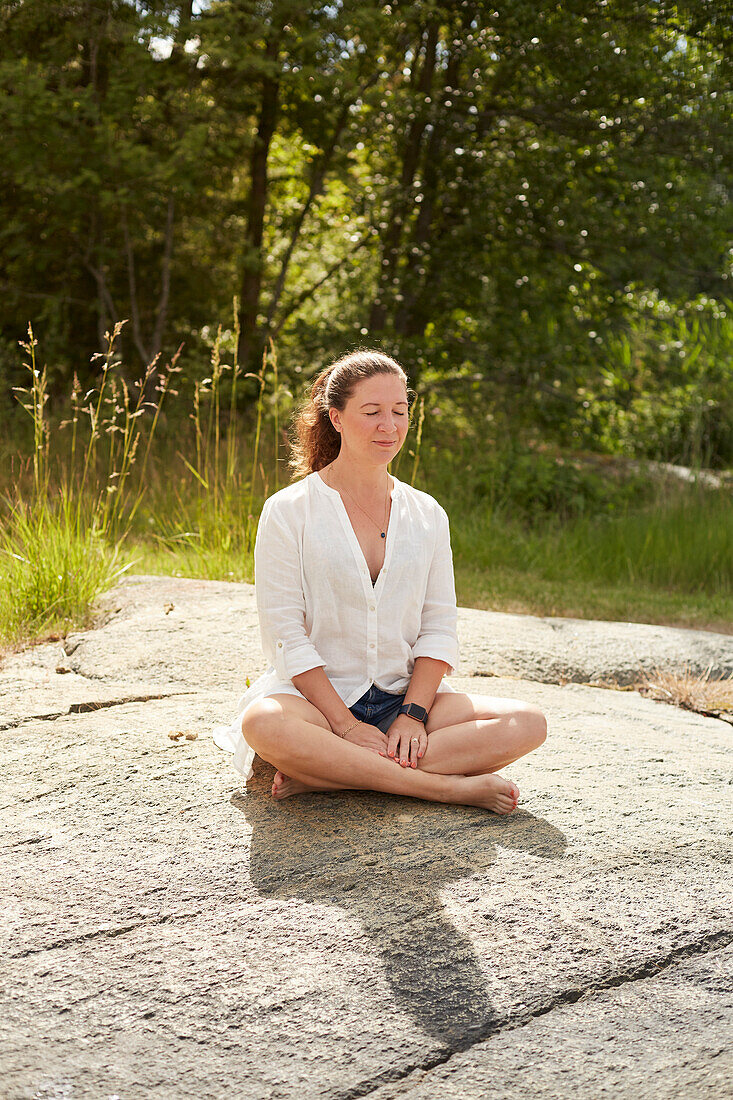 Frau meditiert im Freien