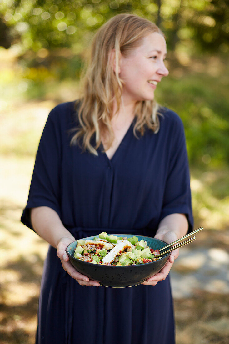Smiling woman holding bowl with food