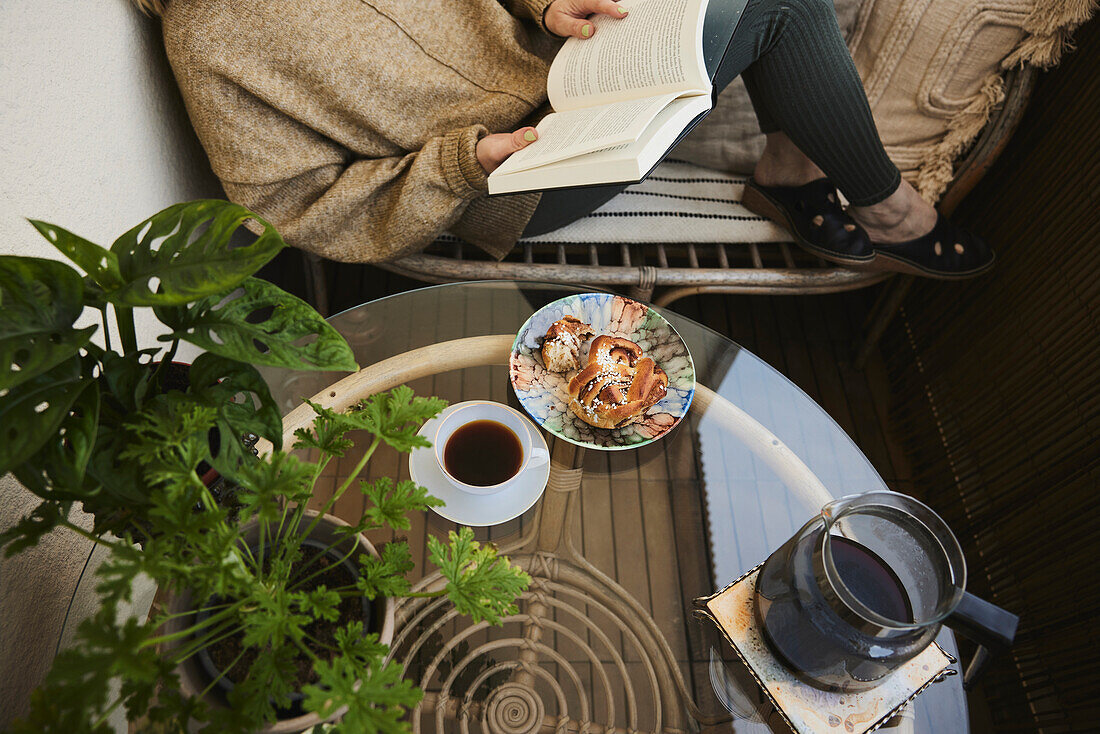 Woman reading book and having tea and snack
