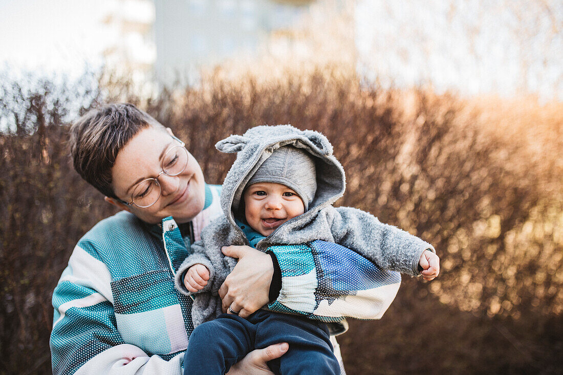 Smiling mother carrying baby