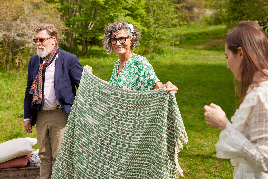 Smiling woman holding picnic blanket