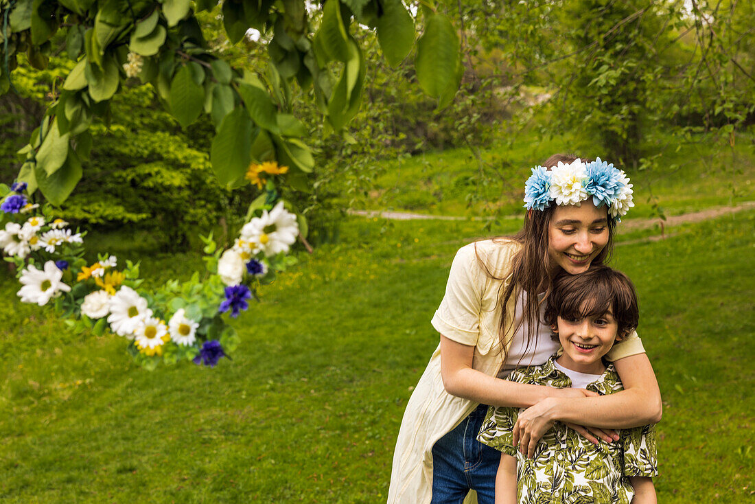 Mother hugging son in garden