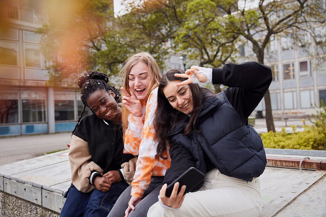 Drei junge Studentinnen machen ein Selfie auf dem Campus