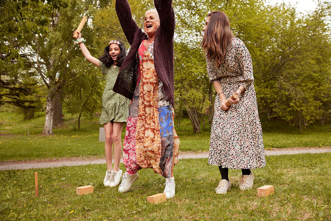 People playing molkky outdoors and cheering