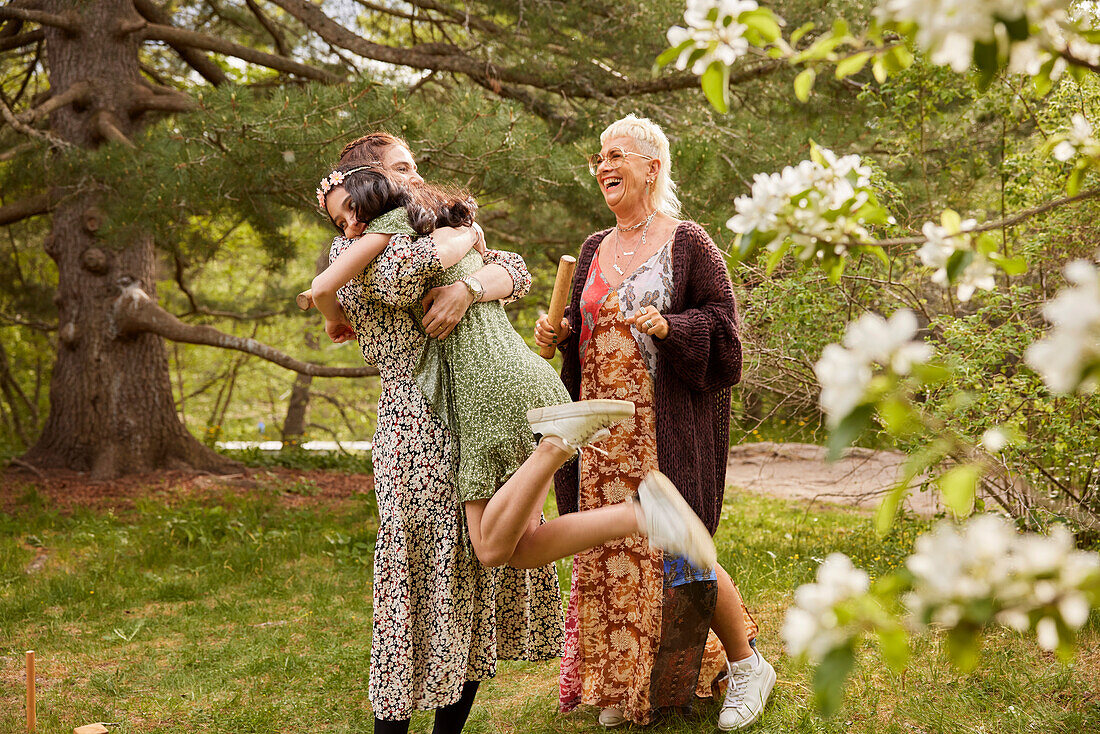 Mother hugging daughter outdoors