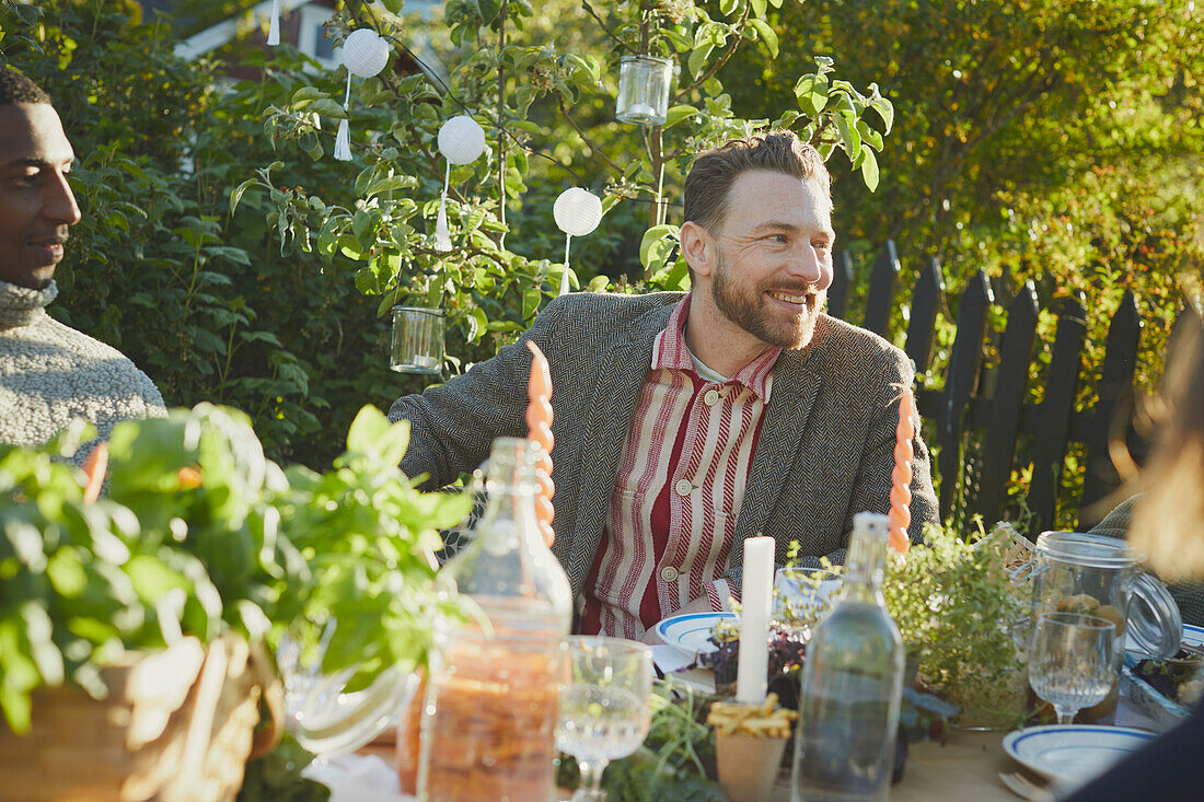 Lächelnder Mann am Tisch im Garten