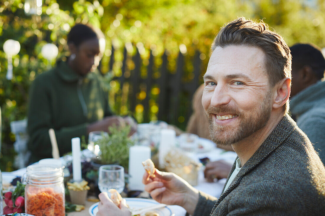 Smiling man at table in garden