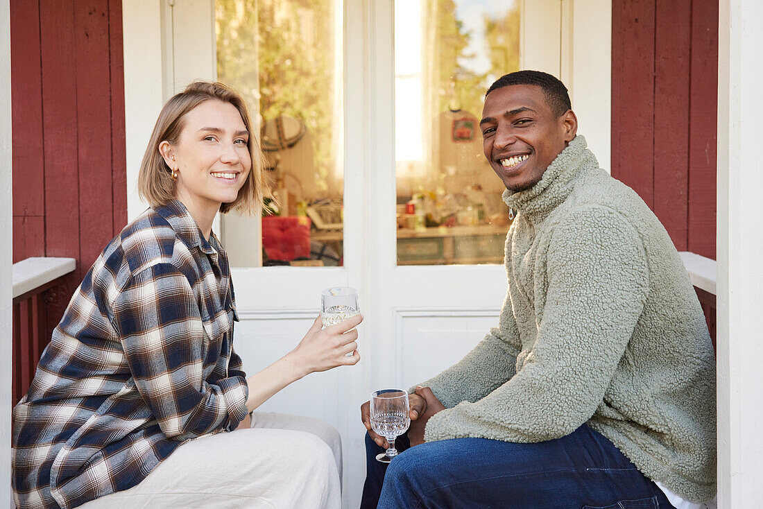 Couple sitting in front of wooden house