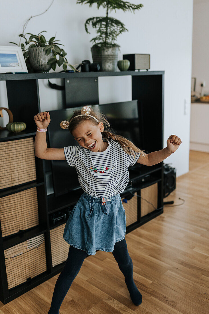 Lächelndes Mädchen tanzt zu Hause