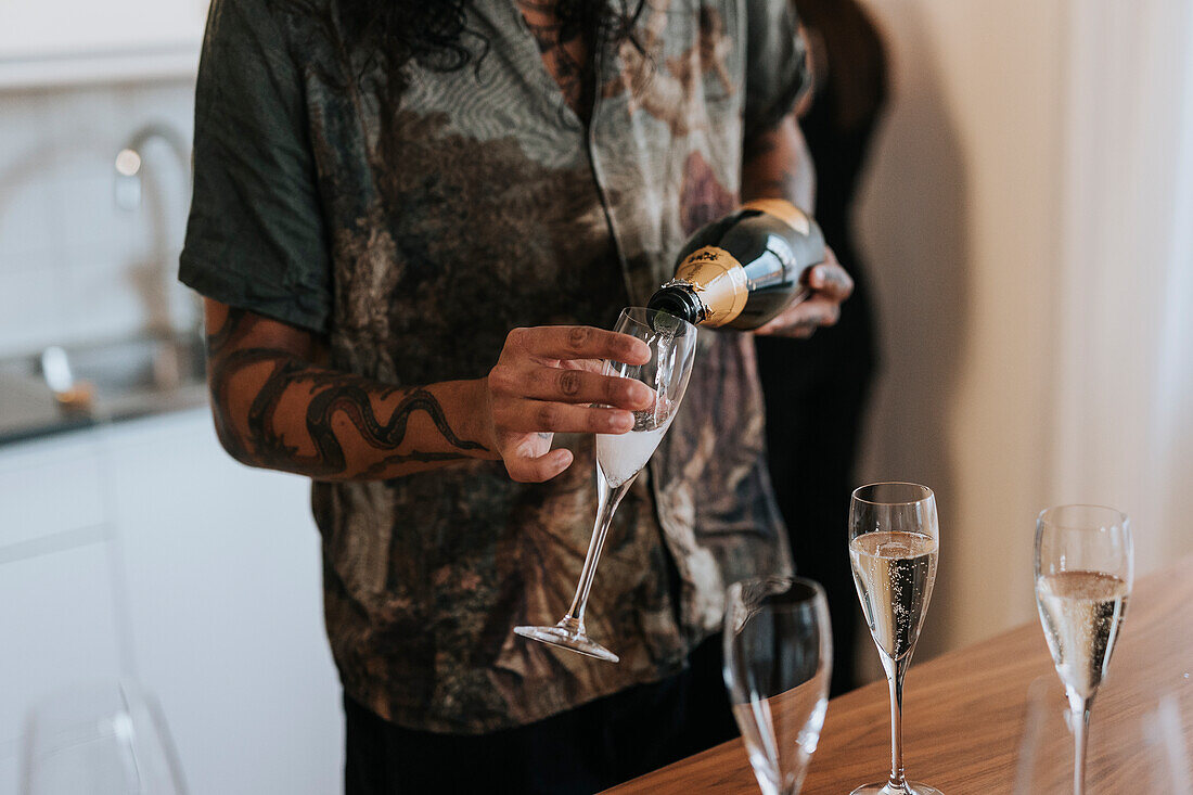 Mid section of man pouring champagne