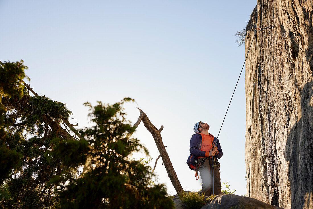 Male rock climber belaying