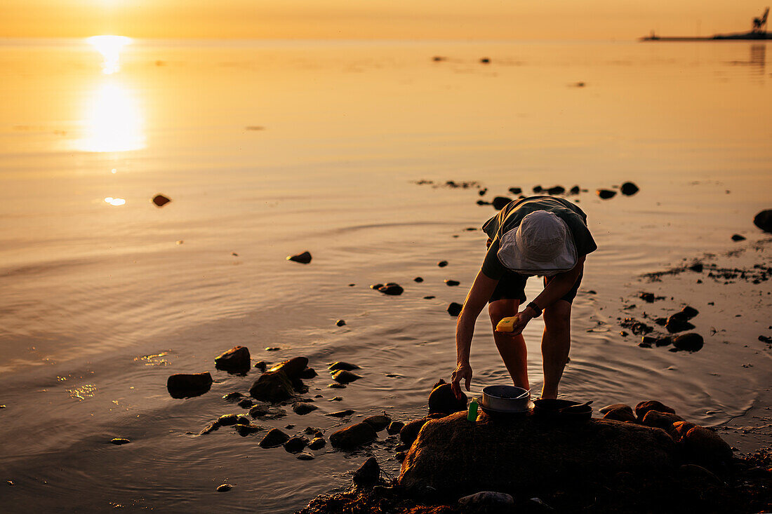 Woman washing dishes at sea