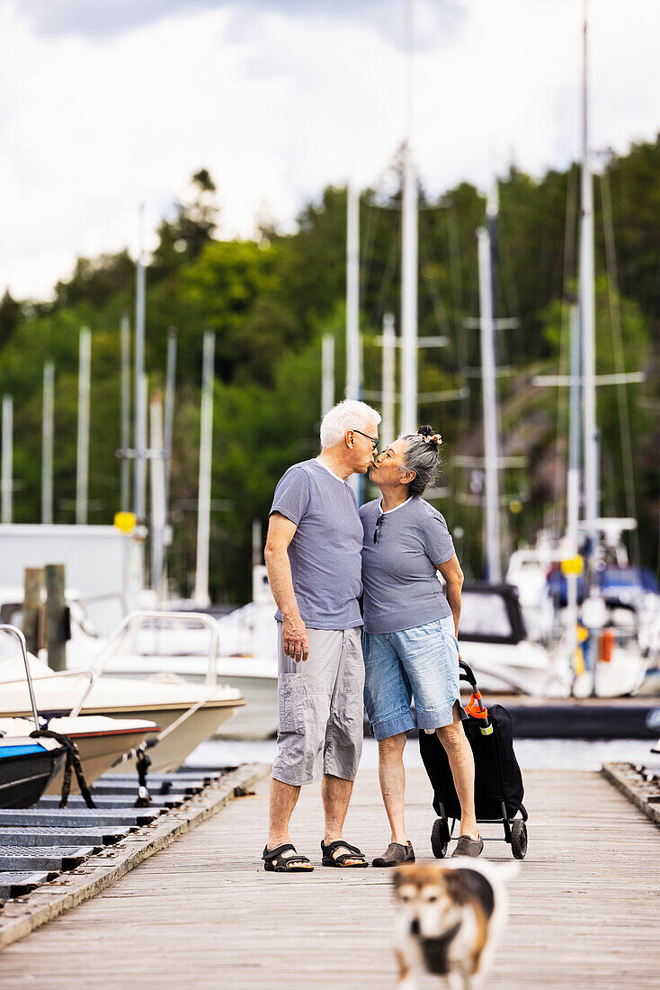 Senior couple kissing on pier