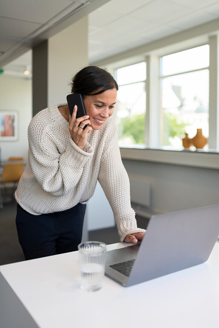 Woman using phone in office