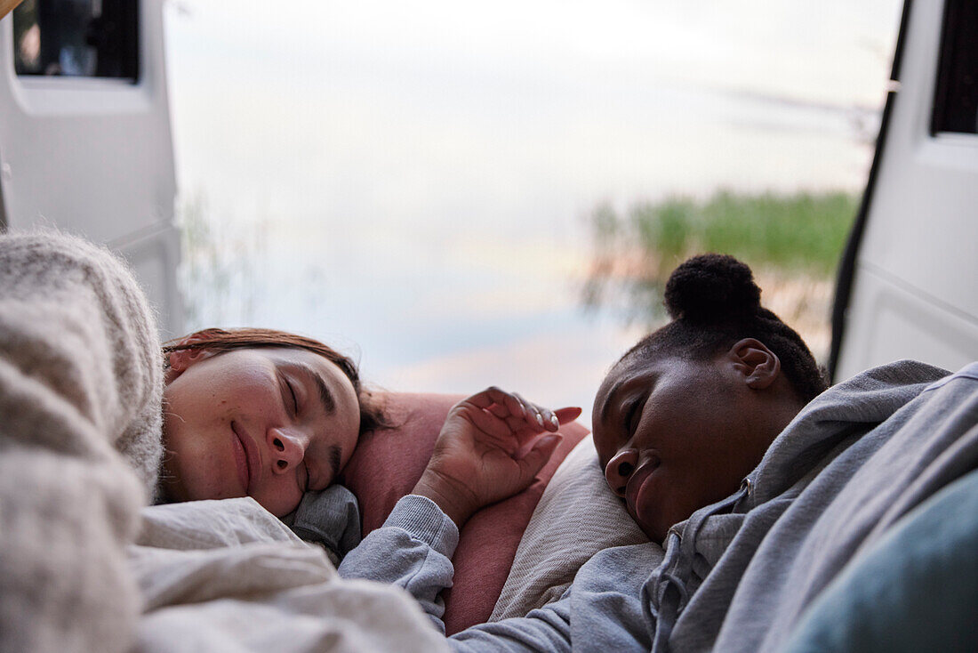 Frauen schlafen im Bett eines Wohnmobils