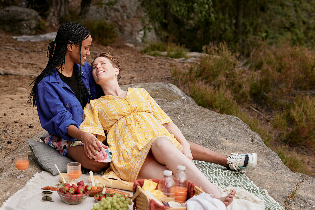 Female couple having picnic on rocks
