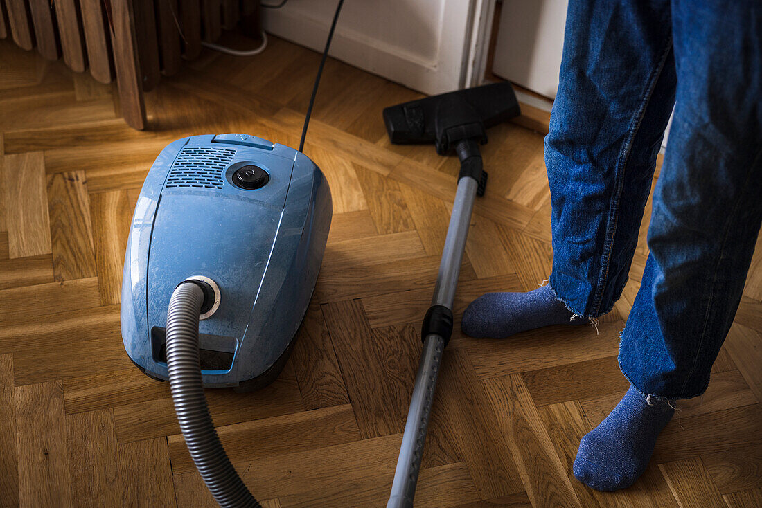 Woman using old-fashioned vacuum cleaner