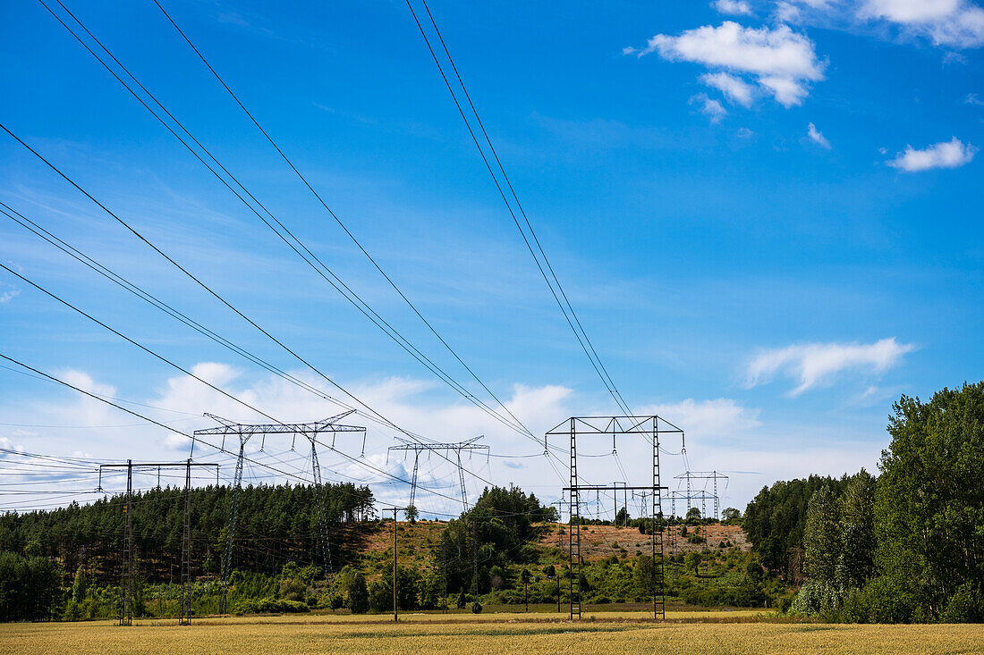 Electricity pylons against blue sky