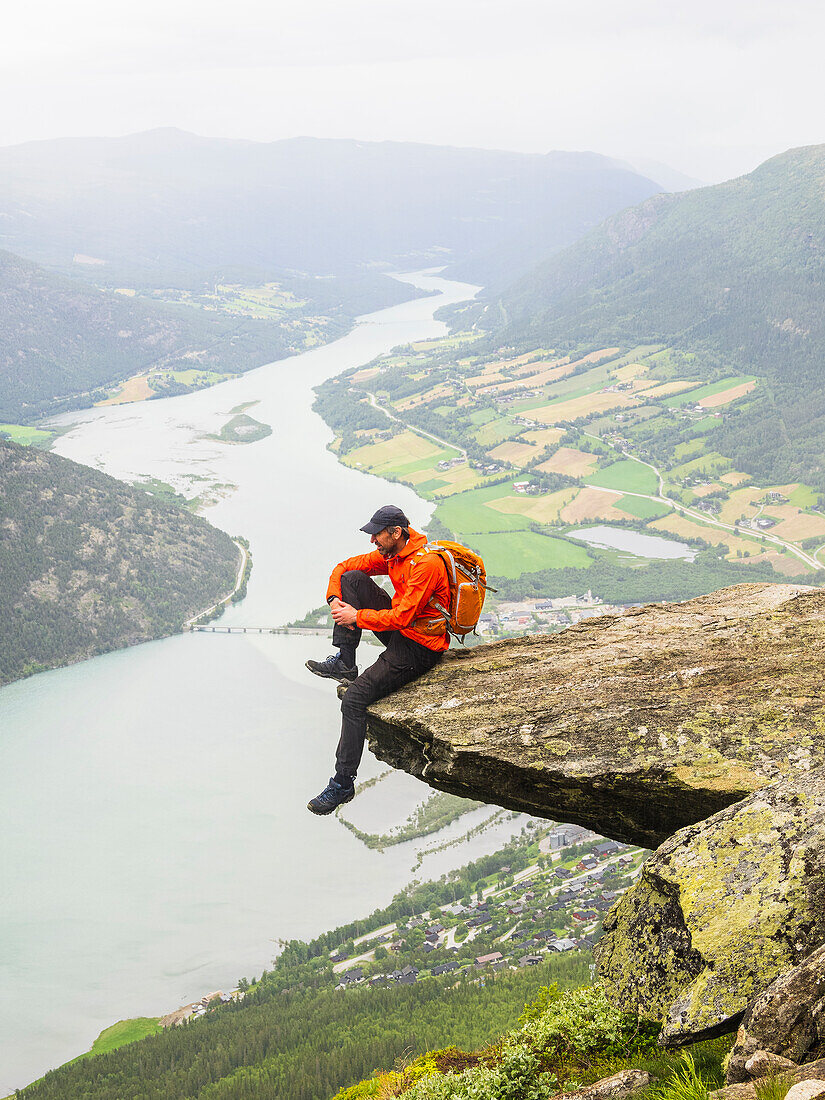 Hiker sitting on rock and looking at view