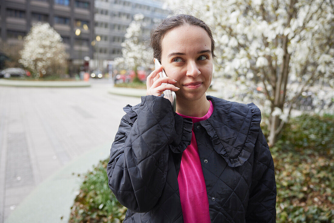 Lächelnde Frau, die mit ihrem Handy spricht