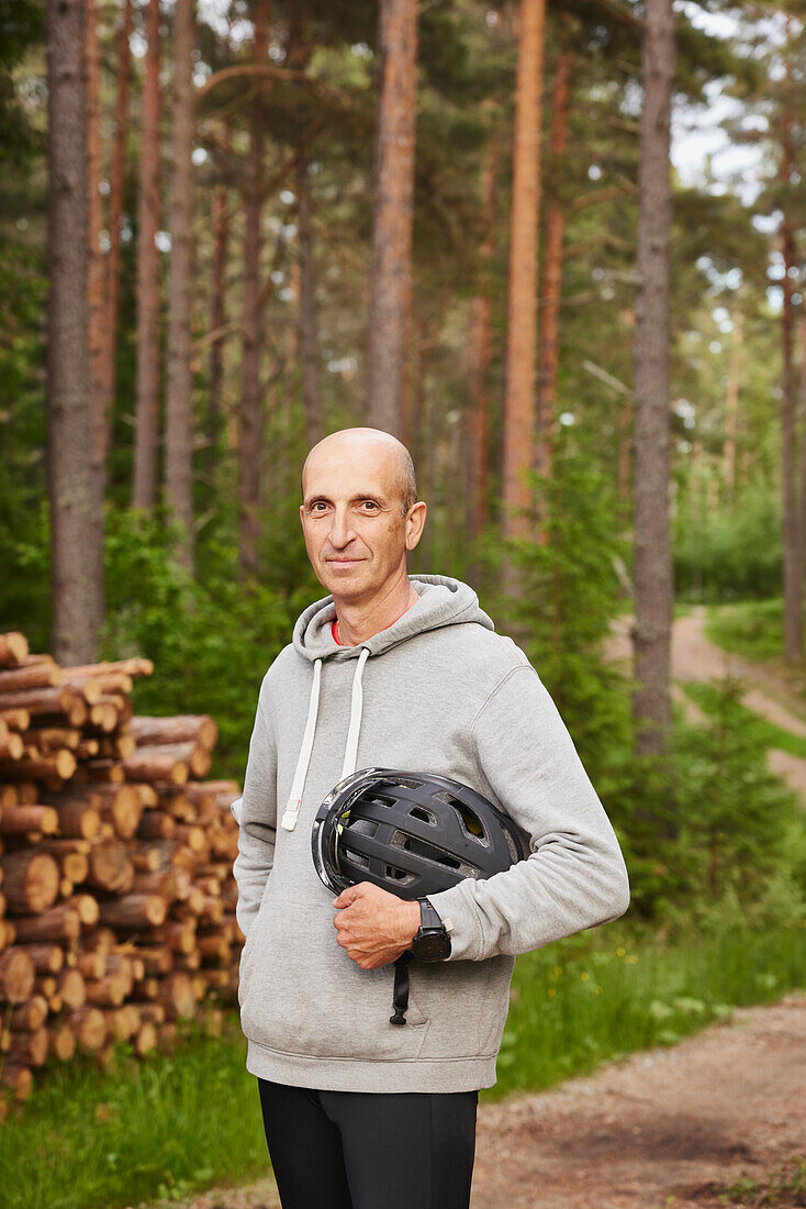 Porträt eines Mannes mit Fahrradhelm im Wald