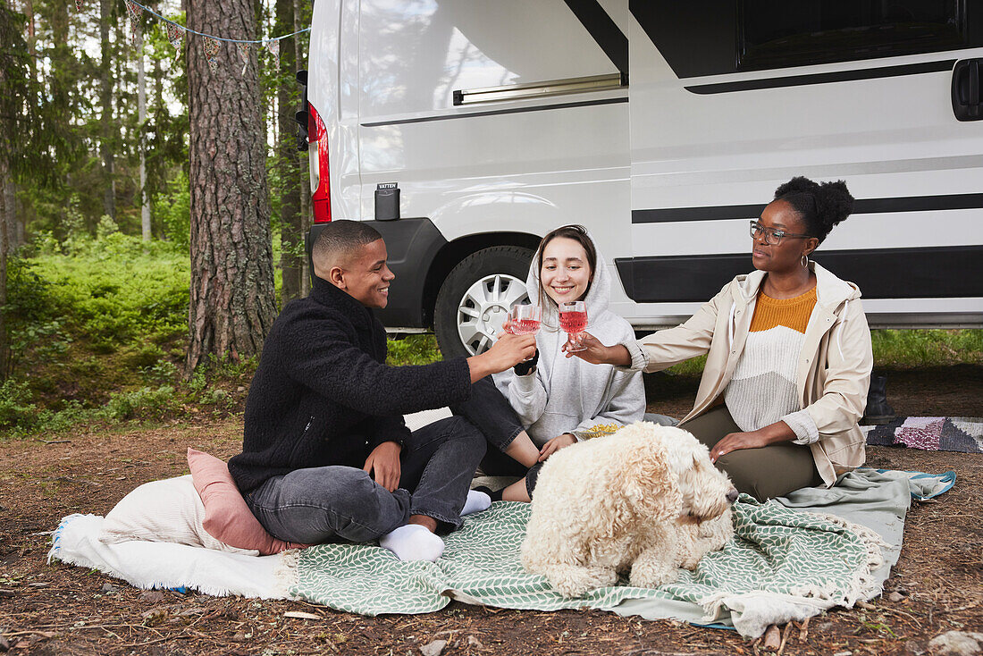 Friends relaxing in front of camper van