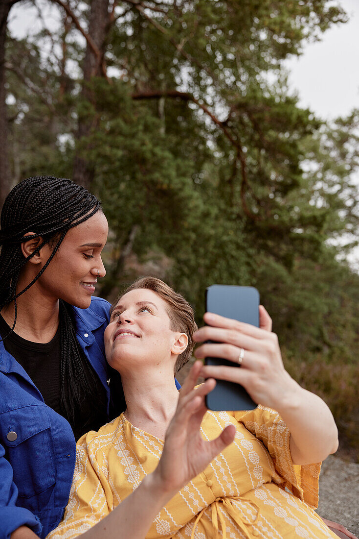 Weibliches Paar macht Selfie im Freien