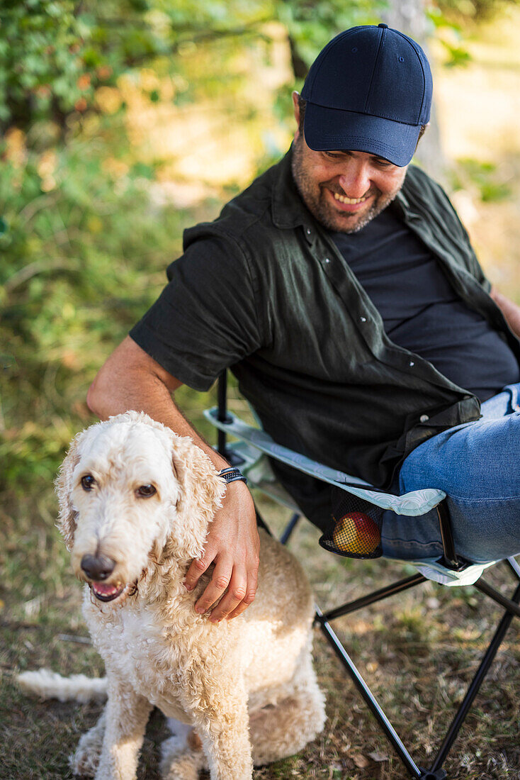 Mann sitzend mit Hund