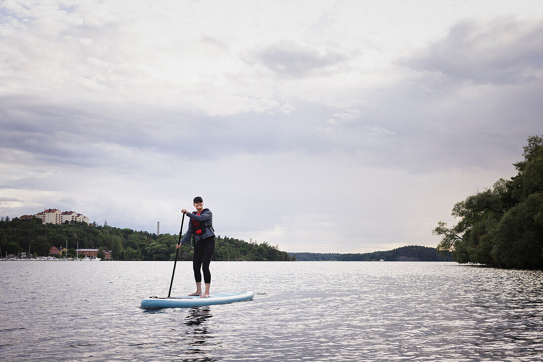 Frau beim Paddeln auf einem See