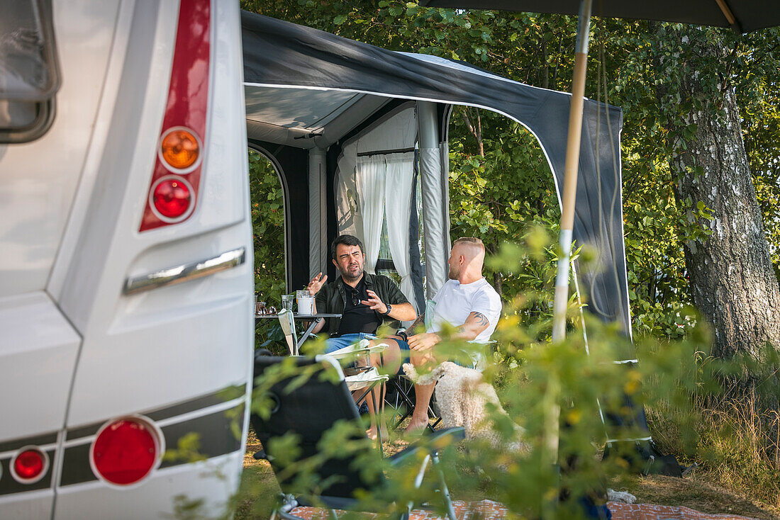 Männer beim Entspannen auf dem Campingplatz