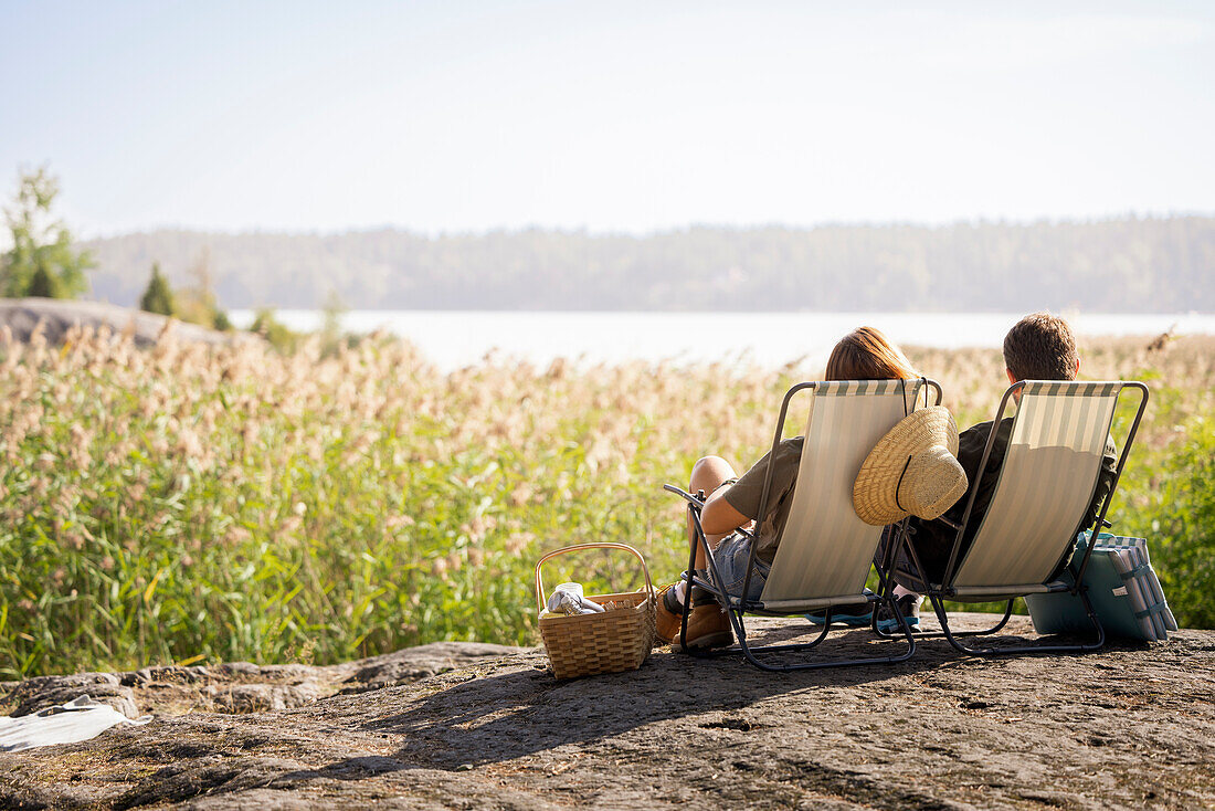 Couple sunbathing on lounge chairs