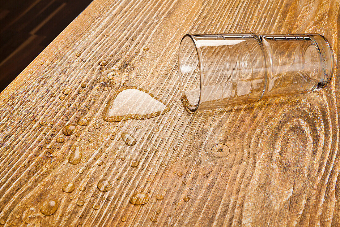 Overturned glass on a wooden table