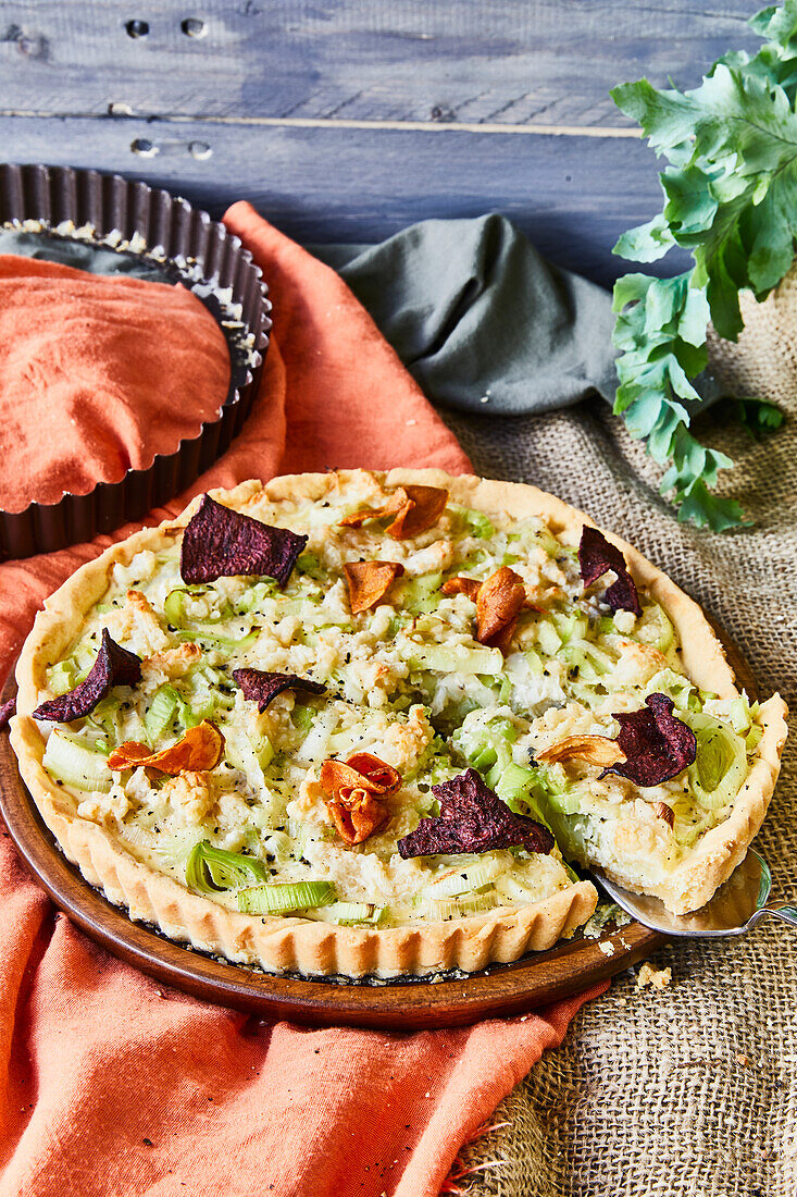 Leek quiche topped with beet and sweet potato chips