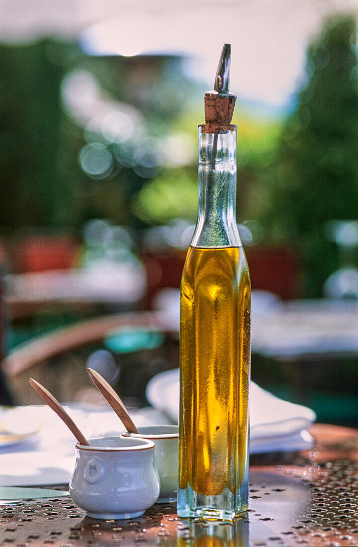 Eine Flasche Olivenöl auf Restauranttisch