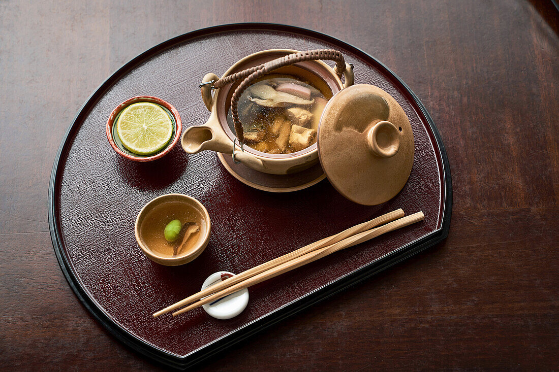 Asiatische Suppe in der Teekanne serviert (Japanische Küche)