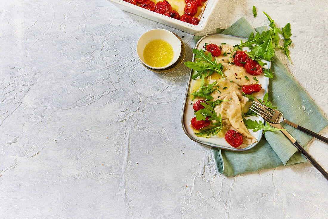Schlutzkrapfen garnished with tomatoes and rocket salad