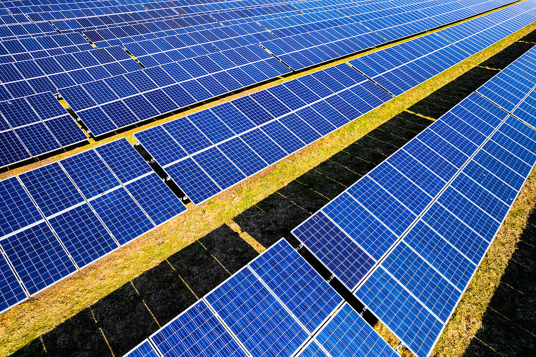 Rows of solar panels at solar farm, UK, aerial photograph
