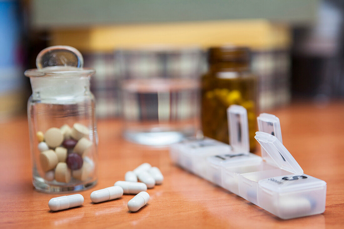 Bottle of pills next to pills on a table