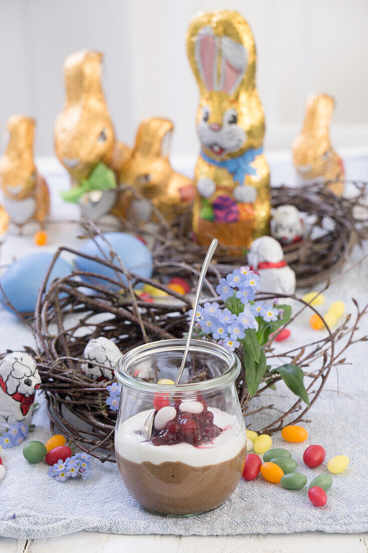 Chocolate mousse with cream and currants in a jar with Easter decorations