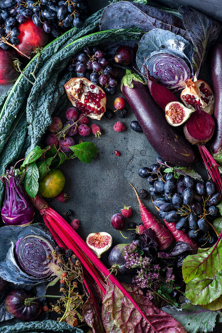 Herbststillleben mit Gemüse und Obst in Violett, um den Bildrand arrangiert