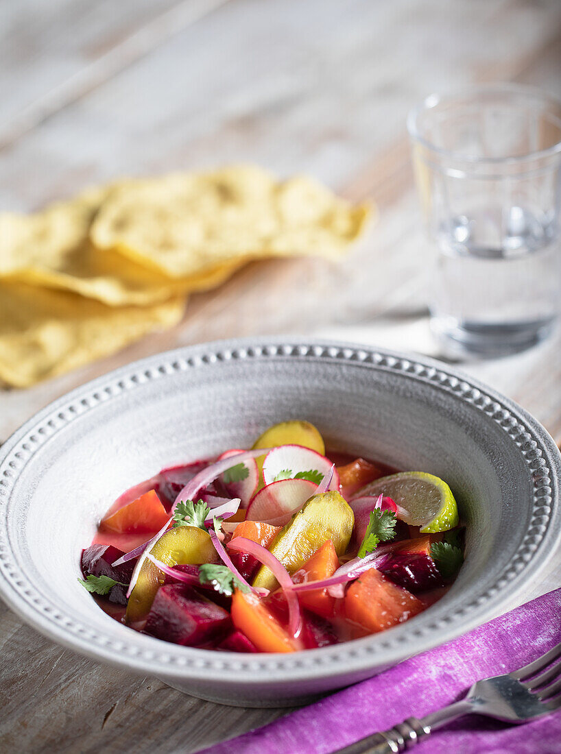 Red and yellow beet salad with radishes, red onion, pickle and lime