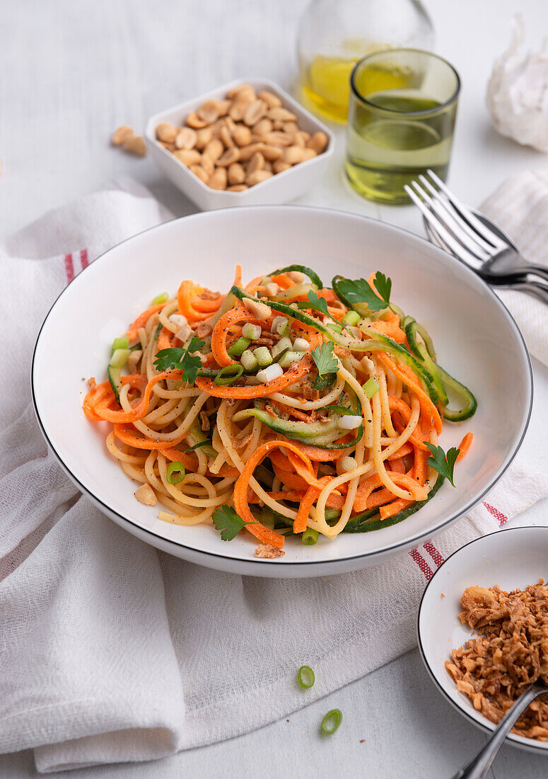 Lukewarm pasta salad with cucumber, carrots, peanut cream dressing and roasted dumplings