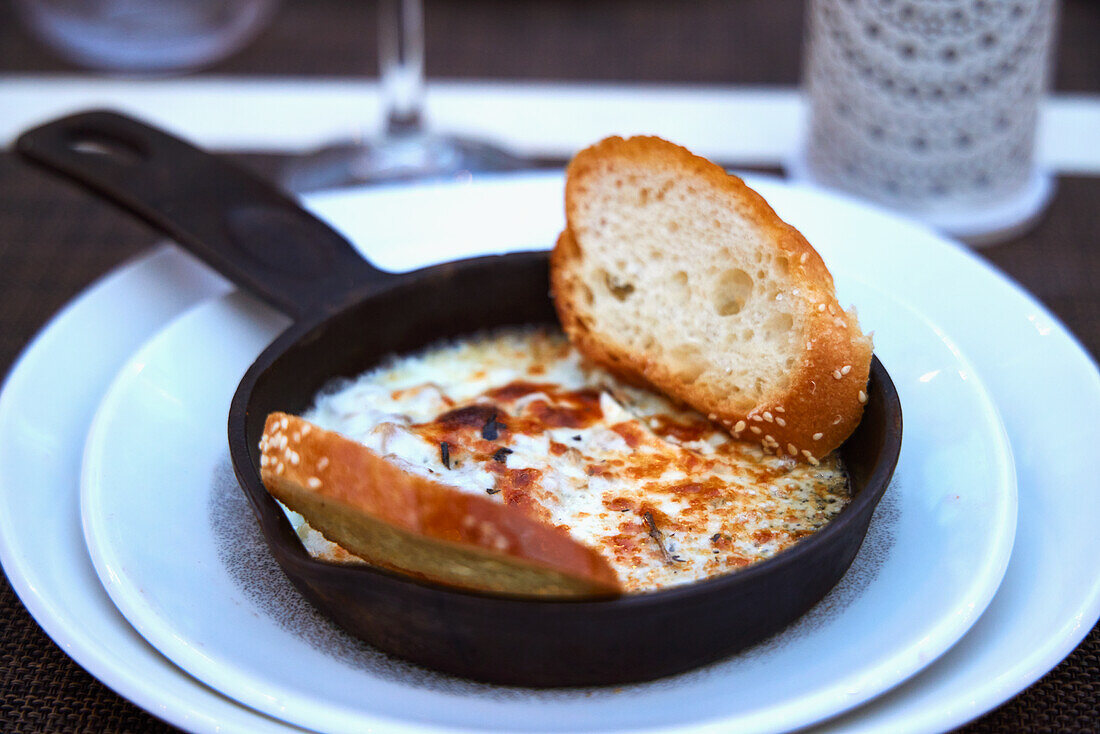 Asiago cheese and mushroom dip with bread in a small pan