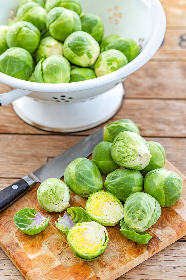Brussels sprouts in a colander and on a cutting board