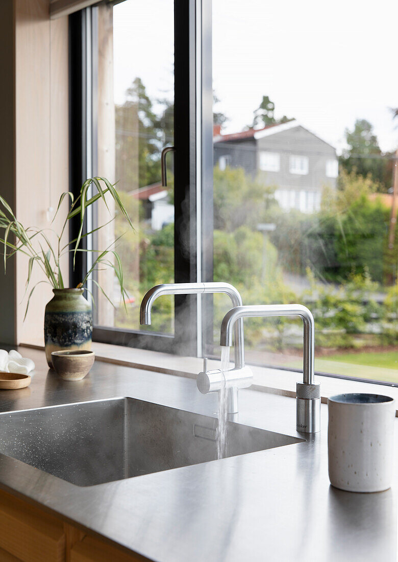 Spülbecken mit Armaturen vor Fenster