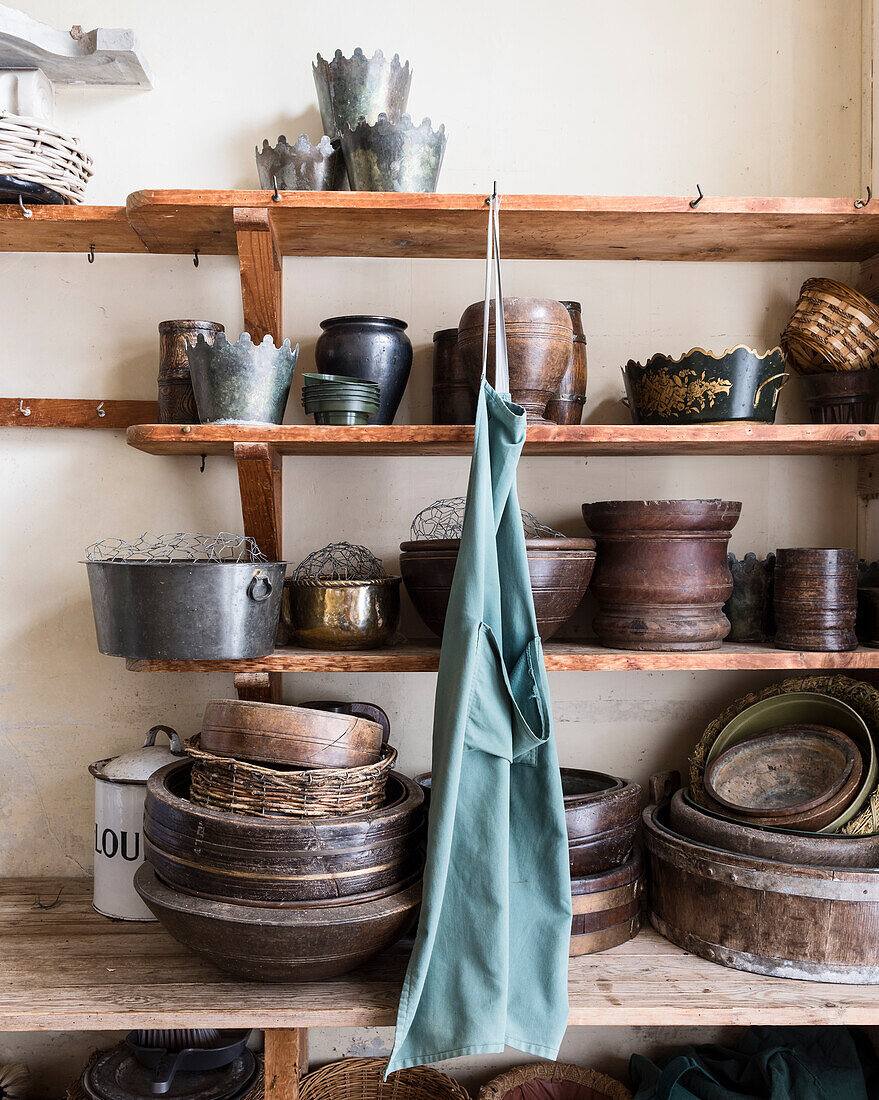 Collection of eathenware gardening pots on wooden shelves