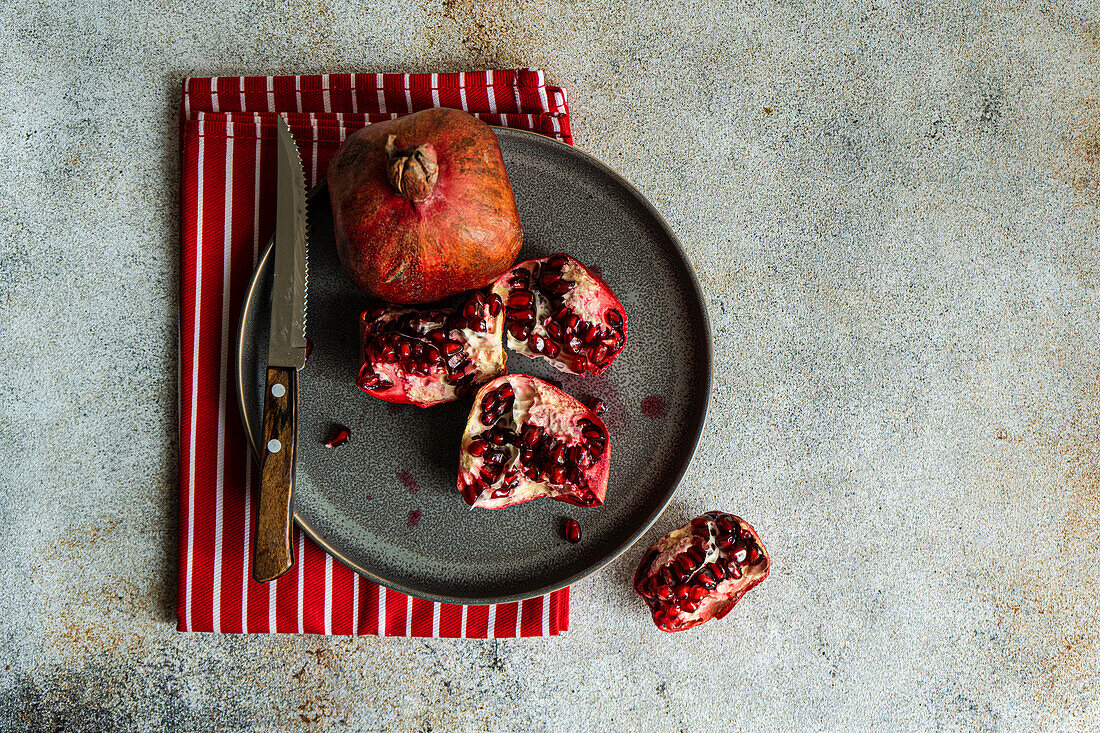 Organic pomegranate fruits with its seeds on black stone background